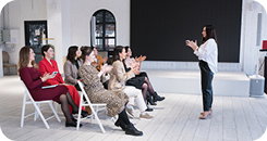Palestra educacional da Amplia Plataforma de Ensino, com educadores participando de formação e aplaudindo a apresentação.