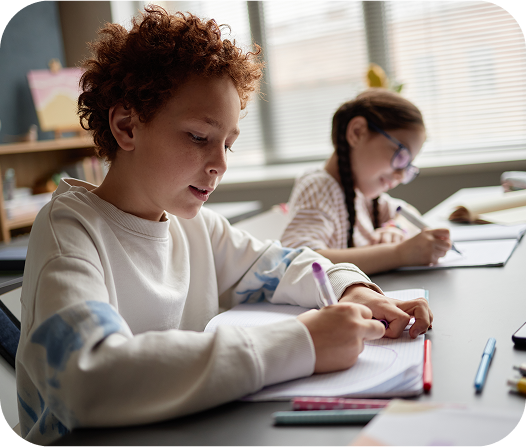 Estudantes realizando atividades escritas em sala, com o suporte de materiais da Amplia Plataforma de Ensino.
